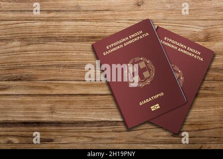 Greek passports are issued exclusively to Greek citizens for the purpose of international travel, Greek passport on a wooden background Stock Photo
