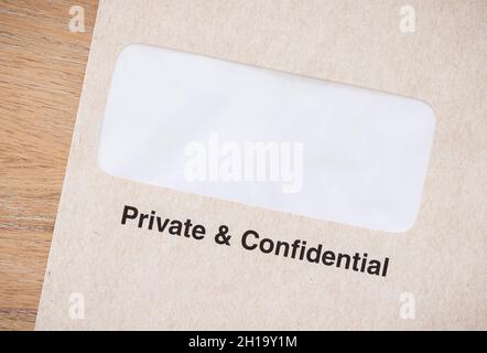 Private and confidential business envelope on a desk. Window envelope for confidential documents, UK Stock Photo