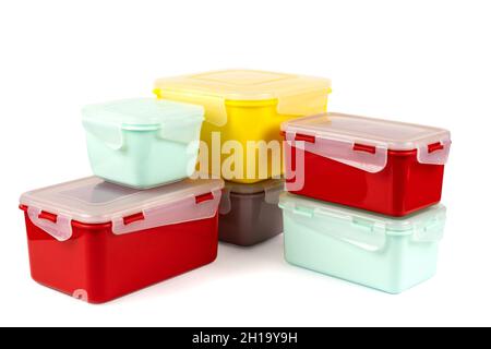 Multicolored plastic lunch boxes folded at corner on white background, side view Stock Photo