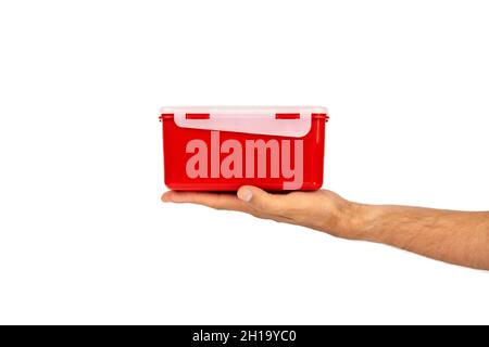 Red plastic food container in hand isolated on white background. Side view Stock Photo