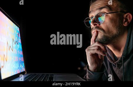 A man analyzing stock market charts, financial data on an electronic board. Stock Photo