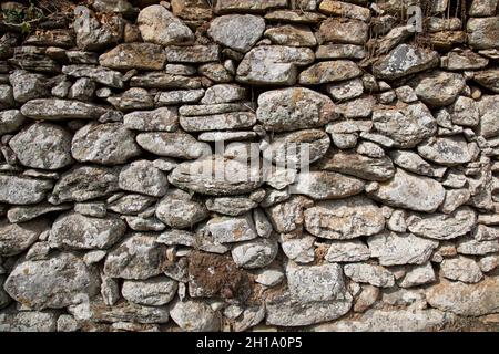 Rough texture of the ancient natural stone wall Stock Photo