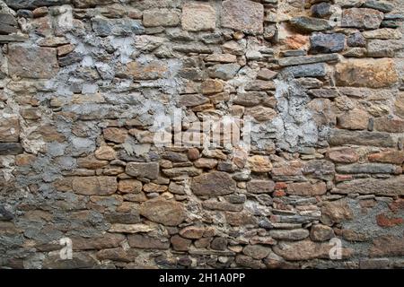 Rough texture of the ancient natural stone wall Stock Photo