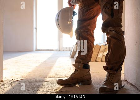A man builder with a helmet in his hands, copy space. Stock Photo