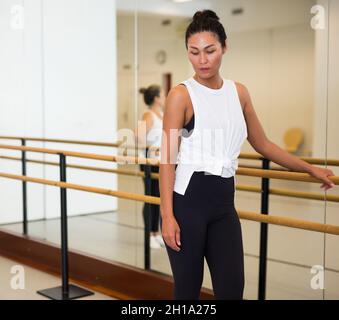 Portrait of tired ballerina at ballet barre in ballet class Stock Photo