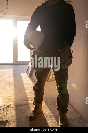 A man builder with a helmet in his hands. Stock Photo