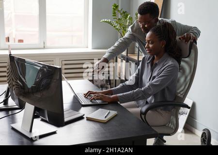 Portrait of two African-American young people collaborating on project while using computer together in office, copy space Stock Photo