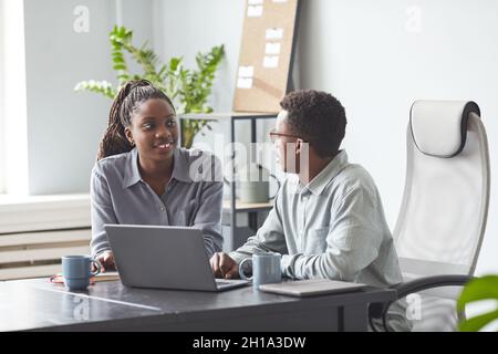 Portrait of two young African-American colleagues collaborating on project while using laptop together in office, copy space Stock Photo