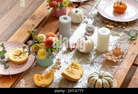 Festive table setting with pumpkins and chrysanthemum flowers. Stock Photo