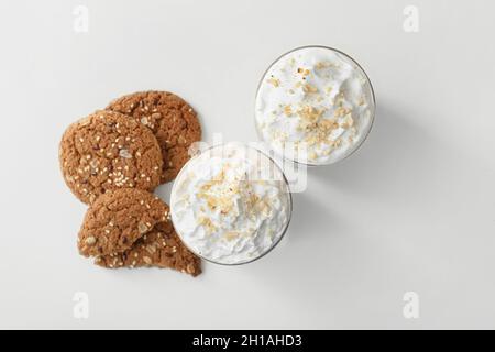 Glasses of tasty latte with nuts on light background Stock Photo