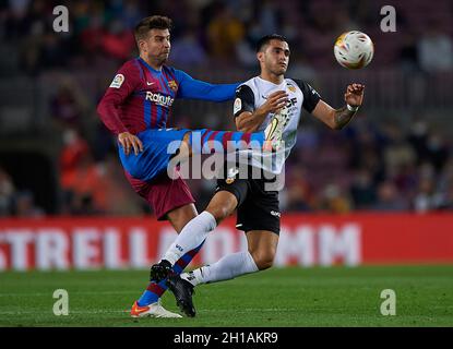 Barcelona, Spain. 17th Oct, 2021. Barcelona's Gerard Pique (L) vies with Valencia's Maxi Gomez during a Spanish first division league football match between FC Barcelona and Valencia CF in Barcelona, Spain, on Oct. 17, 2021. Credit: Pablo Morano/Xinhua/Alamy Live News Stock Photo