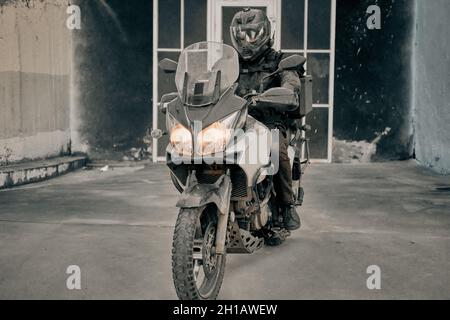 Biker leaves the garage in evening on his motorcycle Stock Photo