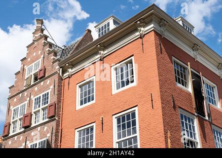 Facades of authentic colorful brick houses, the left one with stepped gable, in the historical center of Delft, The Netherlands. Stock Photo