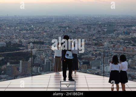 Tokyo, Japan. 15th Oct, 2021. Visitors of Shibuya Sky take photos on the upper floor of the observation deck during sunset.Shibuya Sky is a new attraction for domestic and international tourists with a great view over Tokyo. Credit: SOPA Images Limited/Alamy Live News Stock Photo
