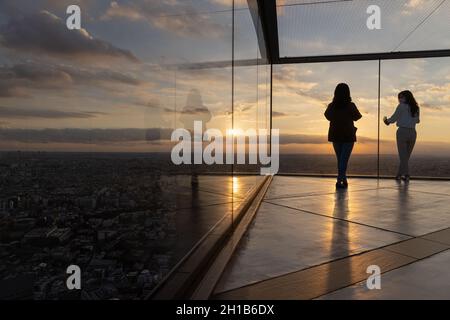 Tokyo, Japan. 15th Oct, 2021. Visitors of Shibuya Sky take photos on the upper floor of the observation deck during sunset.Shibuya Sky is a new attraction for domestic and international tourists with a great view over Tokyo. Credit: SOPA Images Limited/Alamy Live News Stock Photo