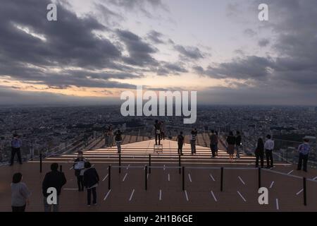 Visitors of Shibuya Sky take photos on the upper floor of the observation deck during sunset.Shibuya Sky is a new attraction for domestic and international tourists with a great view over Tokyo. Stock Photo