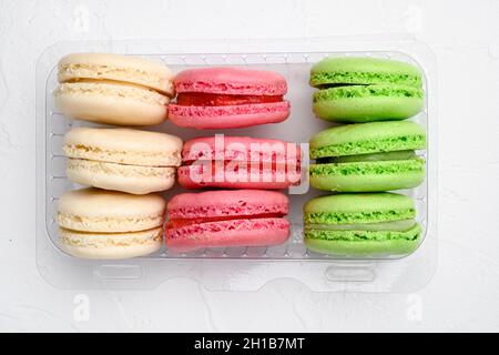 Colorful french macarons set, in plastic pack, on white stone table background, top view flat lay Stock Photo