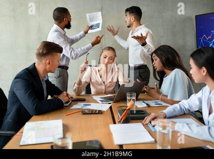 Workplace Conflicts. Stressed Group Of Business People Having Disagreements During Corporate Meeting Stock Photo