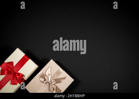 Wrapped vintage gift boxes with red ribbon bow, isolated on black Stock Photo