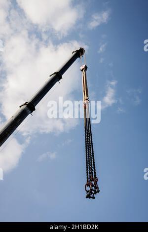 crane boom with hooks on blue sky background Stock Photo