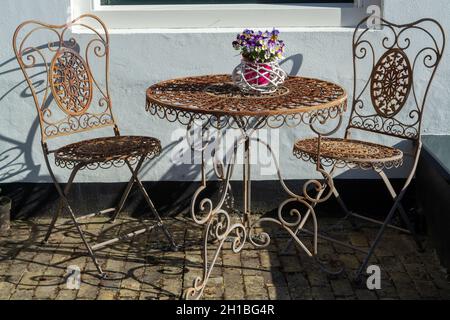 Vintage metal bistro table and chairs set in outdoor cafe, used for breakfast, lunch and dinner on terrace Stock Photo