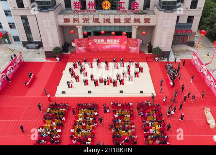 Zhengzhou, Zhengzhou, China. 18th Oct, 2021. On October 16, 2021, the Zhengzhou Federation of Trade Unions held the seventh collective wedding of employees. 35 pairs of new employees from all walks of life departed from the Zhengzhou Olympic Sports Center and arrived in Zhengzhou in two oversized wedding cars built by double-decker buses. City Workers' Home, participate in a grand and romantic collective wedding, and join hands to step into the palace of marriage.Among the 35 pairs of new employees, there are unseen volunteers who are willing to contribute, and industrial workers who lov Stock Photo