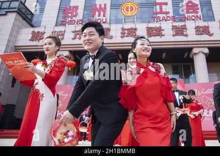 Zhengzhou, Zhengzhou, China. 18th Oct, 2021. On October 16, 2021, the Zhengzhou Federation of Trade Unions held the seventh collective wedding of employees. 35 pairs of new employees from all walks of life departed from the Zhengzhou Olympic Sports Center and arrived in Zhengzhou in two oversized wedding cars built by double-decker buses. City Workers' Home, participate in a grand and romantic collective wedding, and join hands to step into the palace of marriage.Among the 35 pairs of new employees, there are unseen volunteers who are willing to contribute, and industrial workers who lov Stock Photo