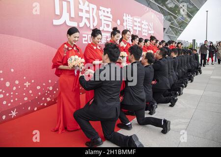 Zhengzhou, Zhengzhou, China. 18th Oct, 2021. On October 16, 2021, the Zhengzhou Federation of Trade Unions held the seventh collective wedding of employees. 35 pairs of new employees from all walks of life departed from the Zhengzhou Olympic Sports Center and arrived in Zhengzhou in two oversized wedding cars built by double-decker buses. City Workers' Home, participate in a grand and romantic collective wedding, and join hands to step into the palace of marriage.Among the 35 pairs of new employees, there are unseen volunteers who are willing to contribute, and industrial workers who lov Stock Photo