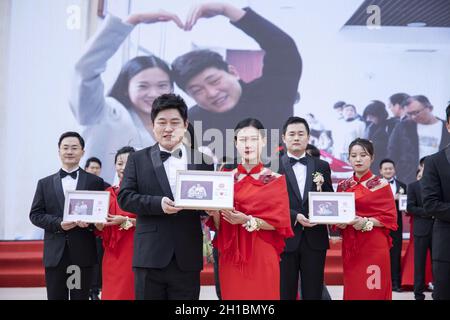 Zhengzhou, Zhengzhou, China. 18th Oct, 2021. On October 16, 2021, the Zhengzhou Federation of Trade Unions held the seventh collective wedding of employees. 35 pairs of new employees from all walks of life departed from the Zhengzhou Olympic Sports Center and arrived in Zhengzhou in two oversized wedding cars built by double-decker buses. City Workers' Home, participate in a grand and romantic collective wedding, and join hands to step into the palace of marriage.Among the 35 pairs of new employees, there are unseen volunteers who are willing to contribute, and industrial workers who lov Stock Photo