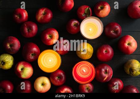 Imperfect red apples and yellow pears on a wooden dark background with candles. Bulk. Top view. Seasonal apples. Russia, Chekhov. Stock Photo