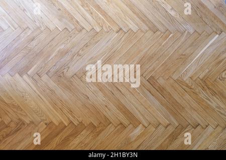 Parquet with herringbone background. Wooden floor with a chevron pattern in the living room of the designer interior. High quality photo Stock Photo