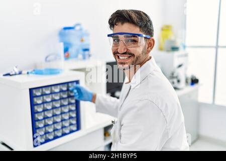 Handsome hispanic man working as scientific at laboratory Stock Photo ...