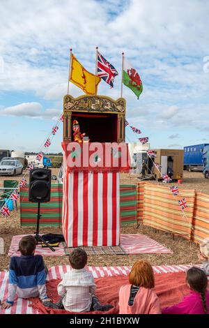Young children kids watching a traditional Punch and Judy puppet show, UK. Stock Photo