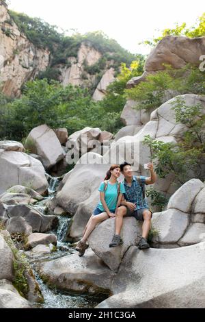 Happy young couple using smart phone outdoors Stock Photo