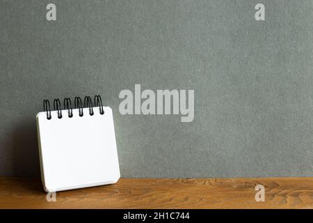 Blank notebook on wooden desk. gray wall background Stock Photo