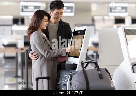 Happy young couple doing self check-in at the airport Stock Photo
