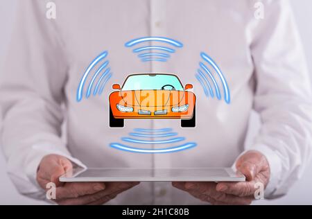 Smart car concept above a tablet held by a man in background Stock Photo