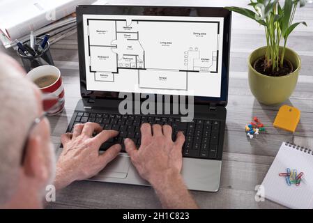 Apartment plan concept shown on a laptop used by a man Stock Photo