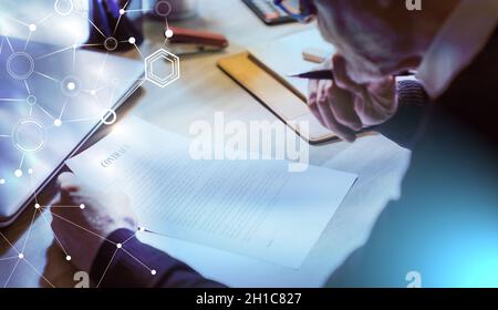 Senior businessman reviewing terms of contract at office; light effect Stock Photo