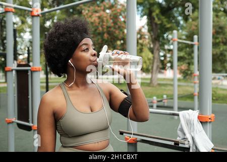 Thirsty fitness girl drink water from bottle, 🇩🇪Professio…