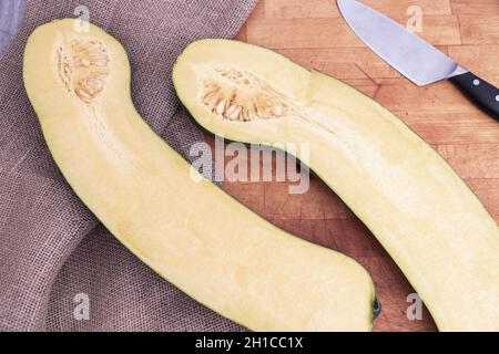 Large pumpkin cut in half on cutting board. Stock Photo