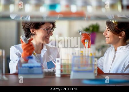Smiling female workers working in laboratory Stock Photo