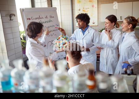 Young chemical students carefully follow a lecturer in the university laboratory in a working atmosphere. Science, chemistry, lab, people Stock Photo