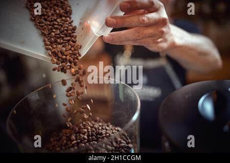 Fragrant and aromatic roasted coffee beans being prepared for grinding. Coffee, beverage, producing Stock Photo