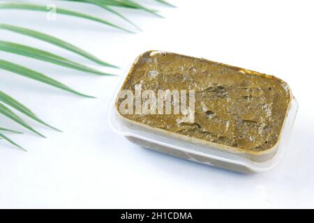 The wooden bowl with rehydrated henna on table Stock Photo