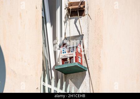 Jawor, Poland - August 08, 2021. Cute tiny birdhouse behind the window Stock Photo