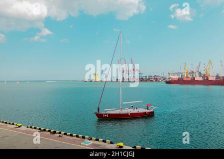 A large pleasure yacht with people moors to the pier on a sunny day.  Stock Photo