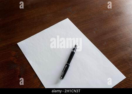 a pen resting on a white sheet of paper Stock Photo