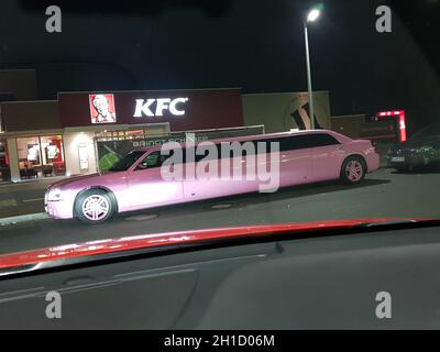 VELBERT, NRW, GERMANY - NOVEMBER 17, 2018: A pink stretch limousine waits for the arrival of passengers in front of a Kentucky Fried Chicken restauran Stock Photo