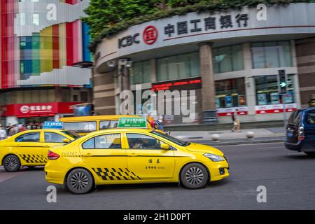 Chongqing, China - August 2019 : Yellow taxi driving on the busy and congested street Stock Photo